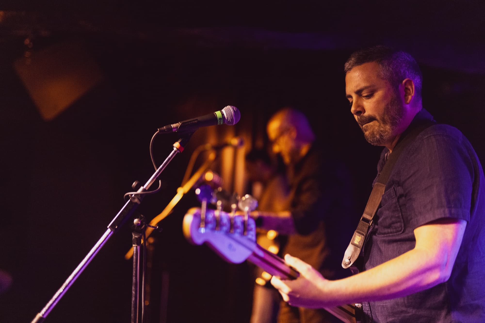 Guitarist performing under stage lights